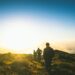 silhouette of three men falling in line while walking during golden hour