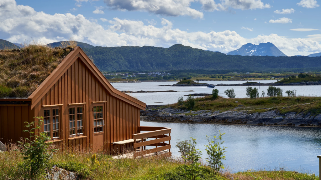 Cabin by a lake with mountains in the distance 